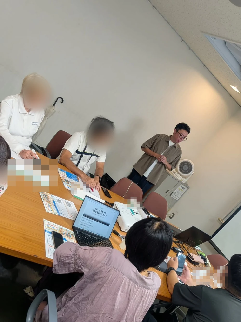 多摩区のAIセミナー当日。参加者がノートPCとスマートフォンを開き、講師の説明を聞いている様子